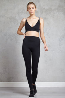 Full body length front view of a women wearing Giselle Legging Full Length - Black and a black sports bra
