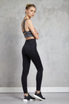 Full body length side view of a woman wearing Kate Legging - Black and a dark heather crop top