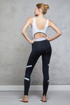 Full body length back view of a woman wearing Caroline Legging - Black / Cornflower and a black and white top