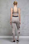 Full body length back view of a woman wearing Caroline Legging - Nude / Black and a matching sports bra