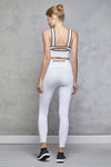 Full body length back view of a woman wearing Chloe Crop Bra - White and matching leggings