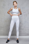 Full body length front view of a woman wearing Chloe Crop Bra - White and matching leggings