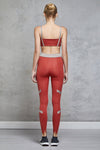 Full body length back view of a woman wearing Caroline Legging - Chilli / Nude with a matching sports bra