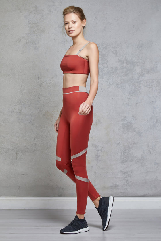 Full body length side view of a woman wearing Caroline Legging - Chilli / Nude with a matching sports bra