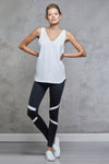 Full body length front view of a woman wearing Sienna Tank - White and black leggings with white stripes