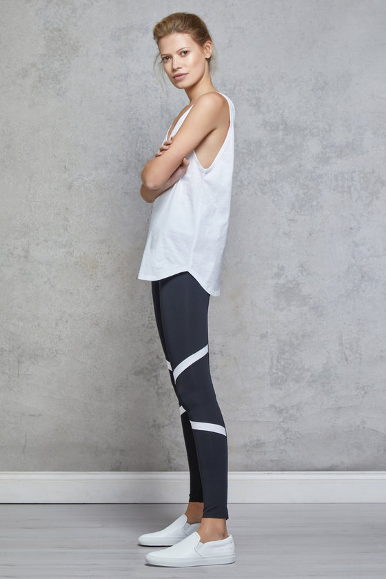Full body length side view of a woman wearing Silou Tee - White and black leggings