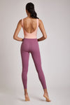 Full body length back view of a woman wearing Mercedes Bodysuit - Coral / Tulipwood