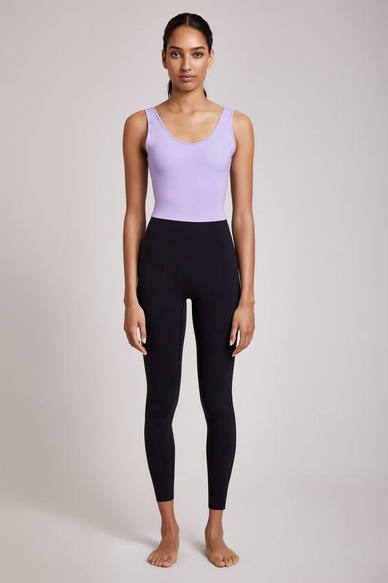 Full body length front view of a woman wearing Mercedes Bodysuit - Lavender / Black