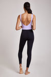Full body length back view of a woman wearing Mercedes Bodysuit - Lavender / Black