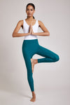 Full body length front view of a woman wearing Mercedes Bodysuit - White / Lagoon in an exercise pose
