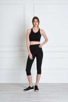  Full body length front view of a woman wearing Nadya Crop Legging - Black and a black crop top